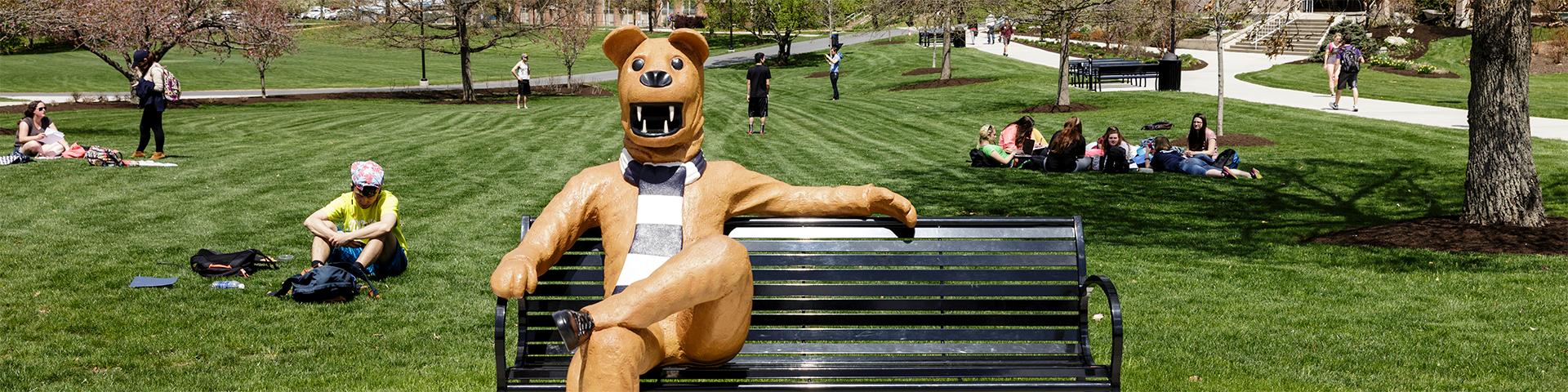 宾州州立大学的伯克斯狮子长椅上，学生们坐在草地上